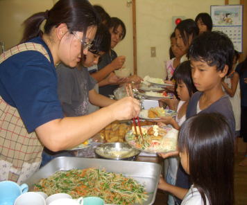 ▲お皿に料理を盛り付ける。子どもたちが喜ぶ様子がボランティアのやりがい。