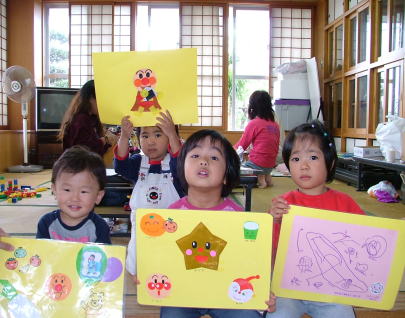 ▲自分たちが描いた絵を誇らしげに掲げる子どもたち。